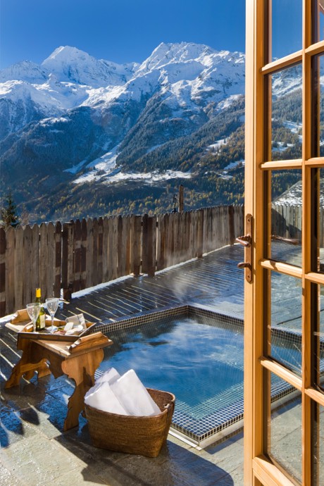 A hot tub wit a fantastic view of snow-covered alps.